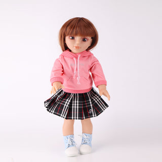 Front view of 18-inch WeGirls Akiko collector makeup artist doll in pink hoodie and houndstooth skirt