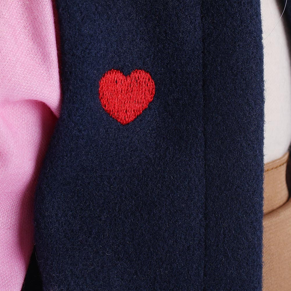 Detailed close-up of heart-shaped embroidery on Lucy doll's outfit