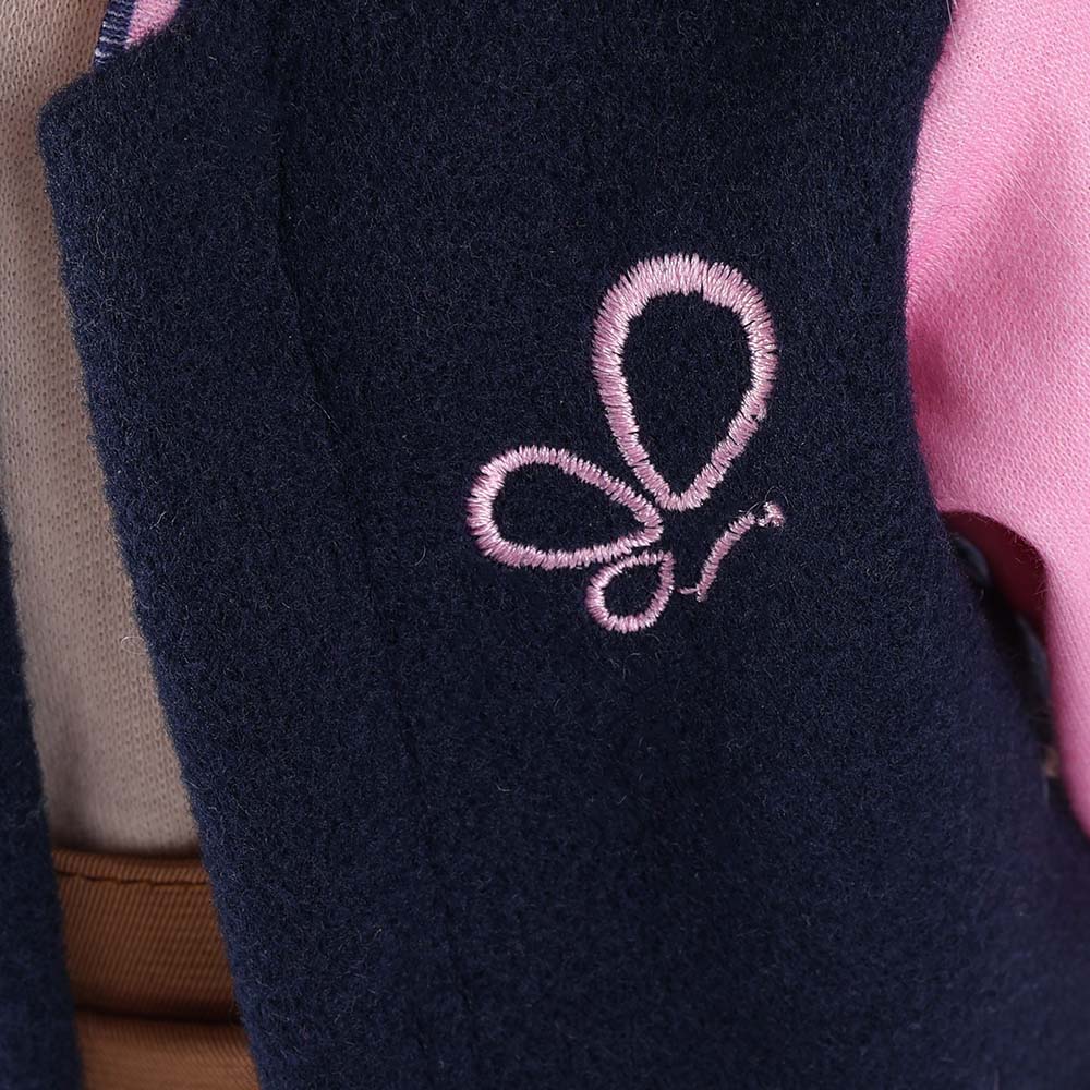 Close-up of delicate butterfly embroidery on Lucy doll's baseball jacket
